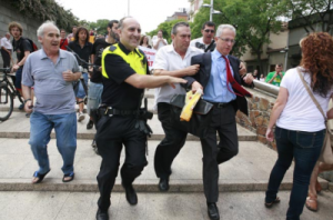 Andreu Fernández Representant de REE, escortat per la policia municipal, fugint de la Plaça de la Vila